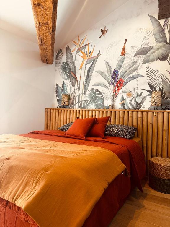 - une chambre avec un grand lit orange et un papier peint tropical dans l'établissement Calme et reposant en hypercentre, à Romans-sur-Isère