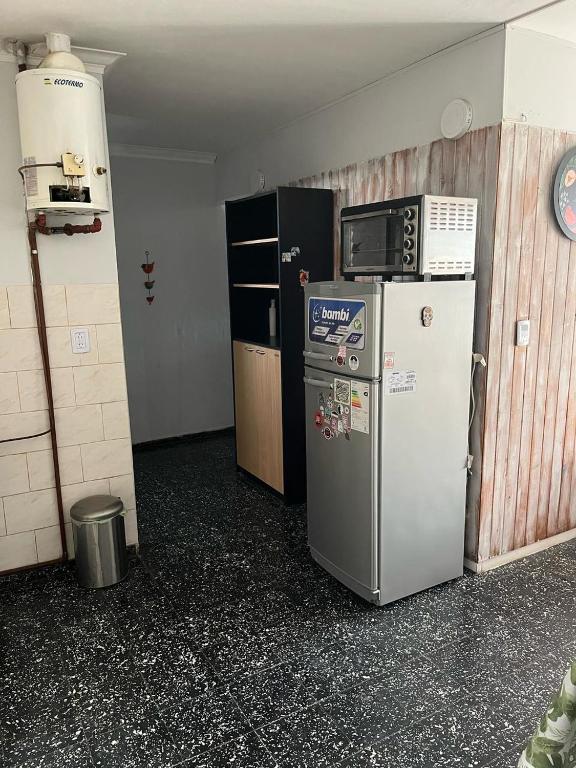 a kitchen with two refrigerators and a microwave on top of a refrigerator at El Refugio House in Maipú