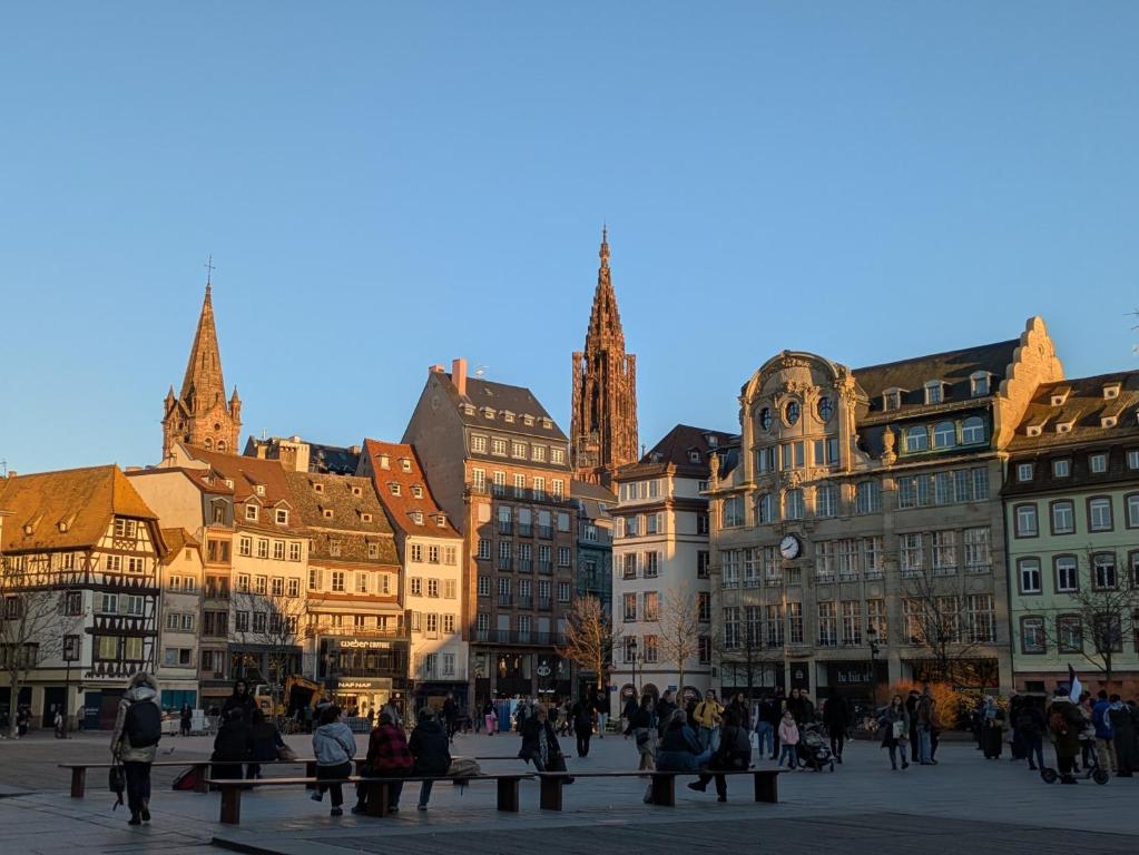 a group of people walking around a city with buildings at La Nuée Bleue in Strasbourg