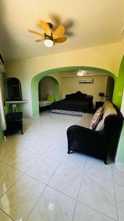 a living room with a couch and a ceiling fan at Casa Jade in Acapulco