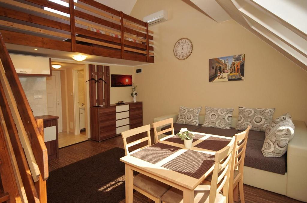 a kitchen and dining room with a table and chairs at Gyulai Brill Apartman in Gyula