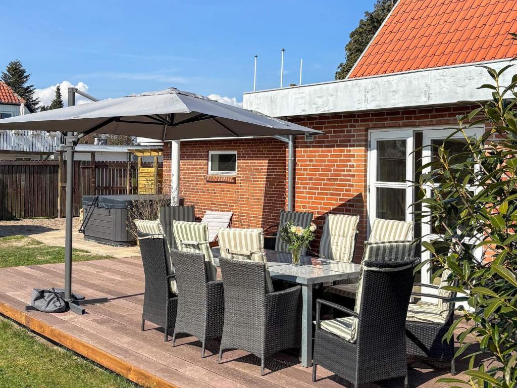 a table and chairs under an umbrella on a deck at 4 star holiday home in Løgstør in Løgsted