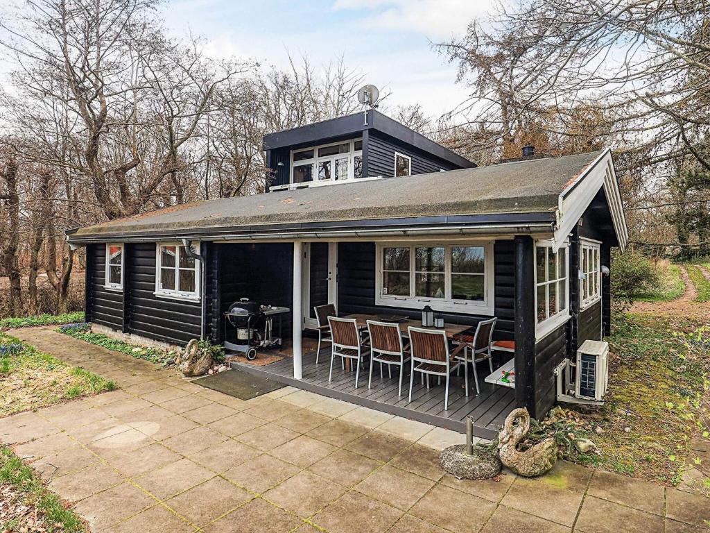 a black tiny house with a table and chairs at 6 person holiday home in Dronningmølle-By Traum in Hulerød