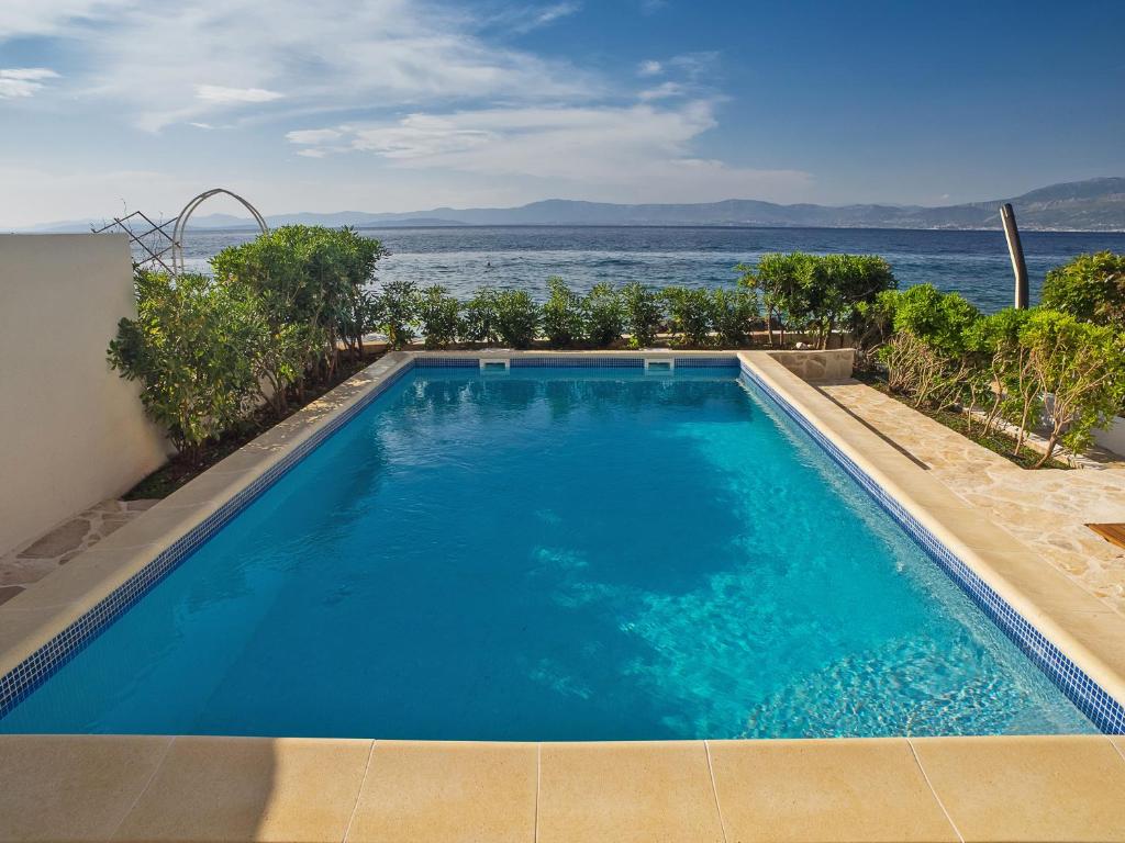 a swimming pool with a view of the ocean at Villas Violet & Rosemary in Supetar