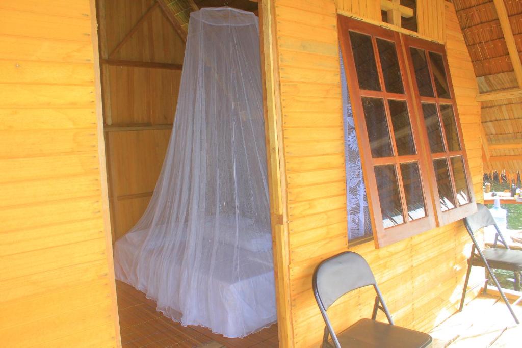 a window with a mosquito net on the side of a house at Ombar Guest House in Minyaifuin