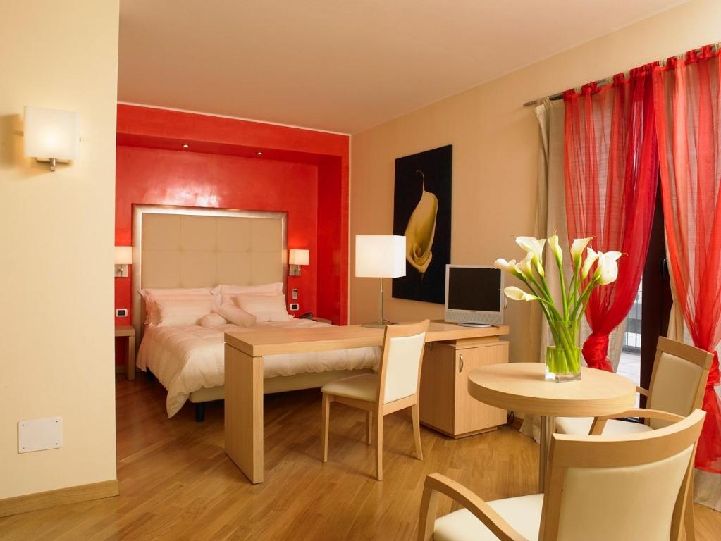 a bedroom with a bed and a desk and a table at Hotel Europa in Padova