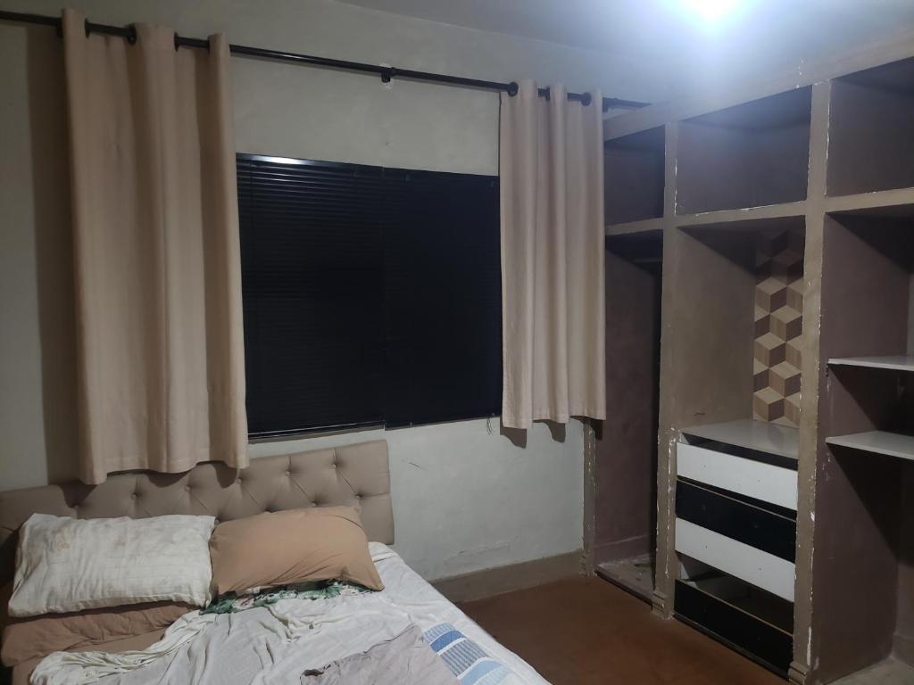 a bedroom with a window and a bed in it at Guest House in Uberlândia
