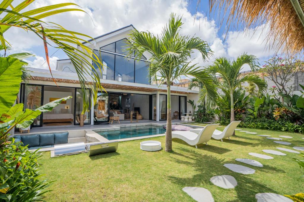 een huis met een zwembad en palmbomen bij NEW! Tropical Palms Villa - 4BR Villa in Kerobokan in Kerobokan