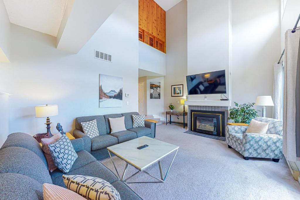 een woonkamer met een blauwe bank en een open haard bij Wintergreen 122 in Blue Mountains