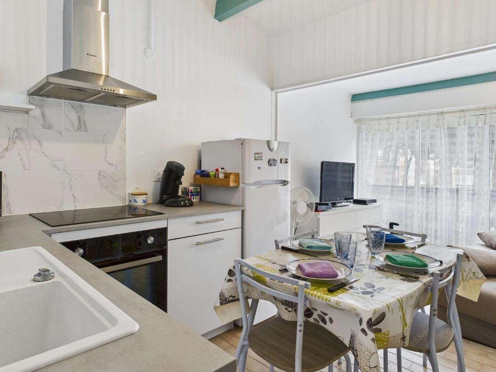- une cuisine avec une table, des chaises et un comptoir dans l'établissement Studio Cabine Lumineux pour 4 au Grau d'Agde avec Vue Piscine et Parking - FR-1-423-323, au Grau-dʼAgde