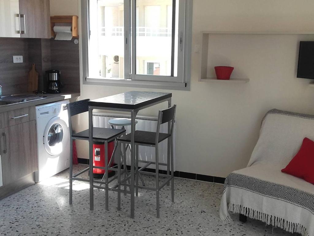 une petite cuisine avec une table et un lave-linge. dans l'établissement Studio 2 Pers Proche Plage avec Parking Privé - FR-1-833-23, à Canet