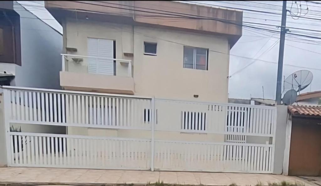 a white house with a white fence at Casa na praia com 2 quartos in Itanhaém
