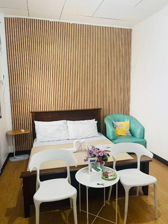 a bedroom with a bed and two tables and a couch at HOST HOMES - CASA ELIZA in Tacloban
