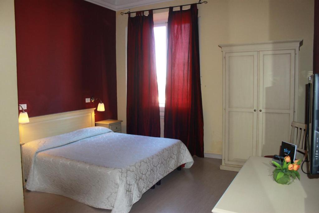 Schlafzimmer mit einem Bett und einem Fenster mit roten Vorhängen in der Unterkunft Hotel Genzianella in Florenz