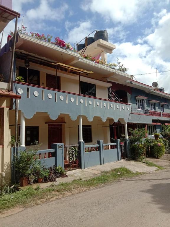 a building with flowers on the top of it at Nakshatra Homestay in Madikeri