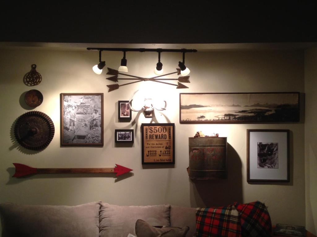ein Wohnzimmer mit Sofa und Bildern an der Wand in der Unterkunft Miner's Camp in Foresthill