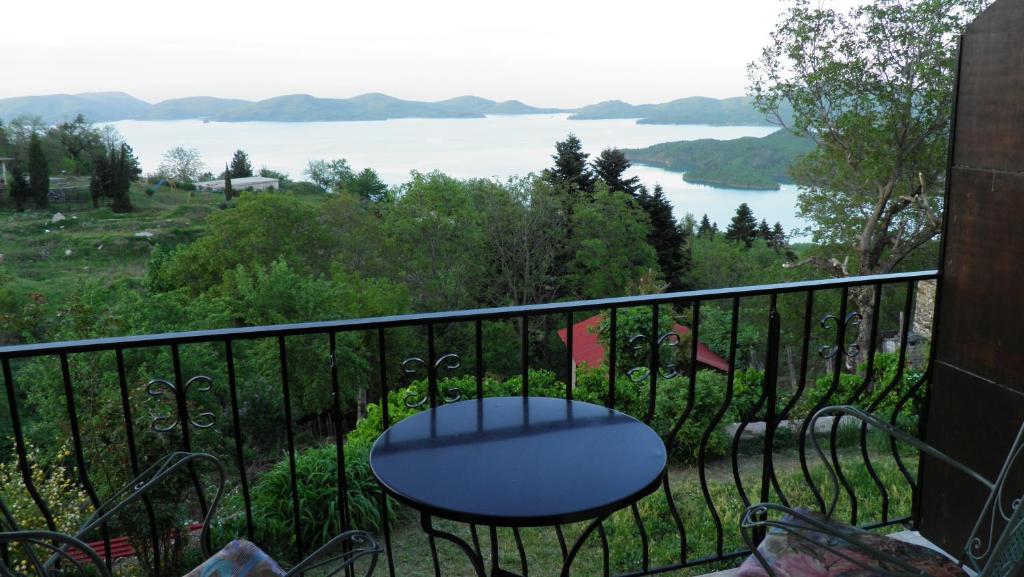 a balcony with a table and a view of a lake at Guesthouse Mitsiopoulou in Neochori