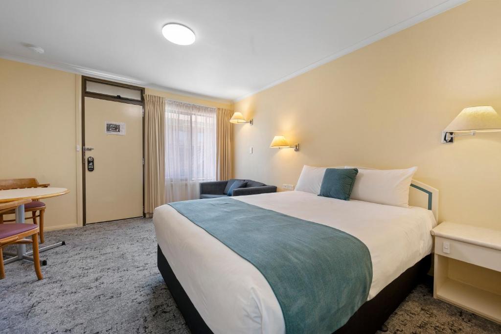 a hotel room with a large bed and a desk at Comfort Inn Devonport in Devonport