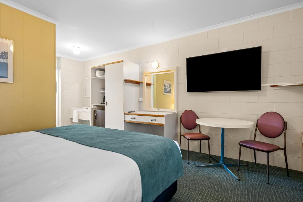 a hotel room with a bed and a table and a tv at Comfort Inn Devonport in Devonport