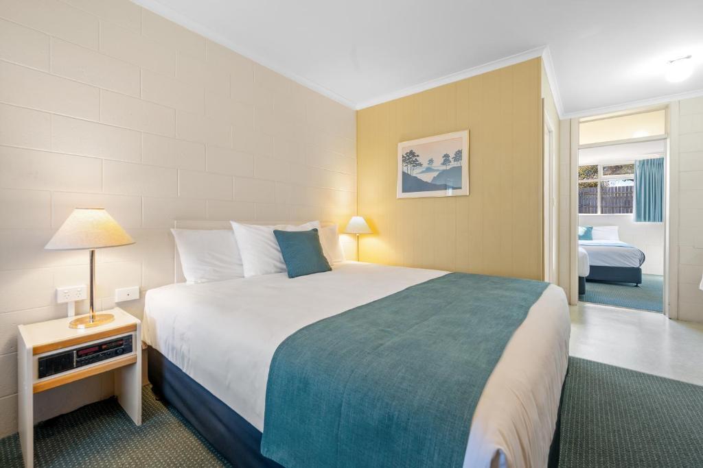 a bedroom with a large bed with a blue blanket at Comfort Inn Devonport in Devonport