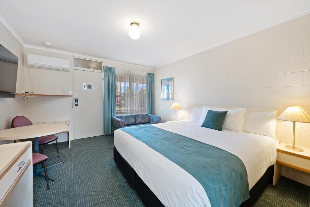 a hotel room with a large bed and a table at Comfort Inn Devonport in Devonport