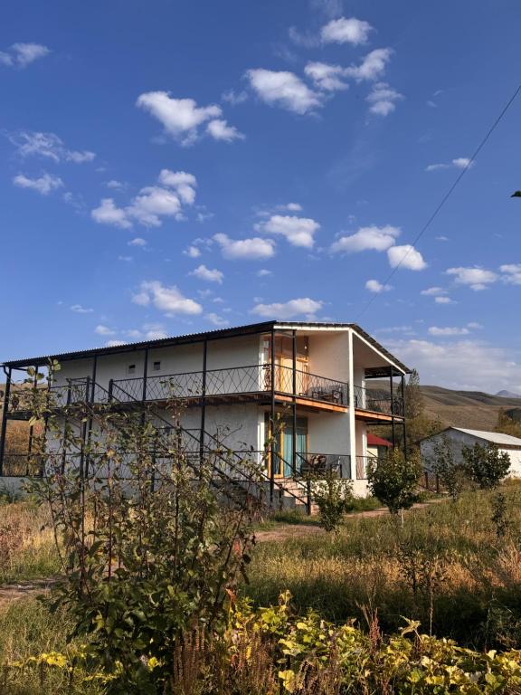 a building in a field with a sky at Eco Village Lodge in Dzhetyoguz