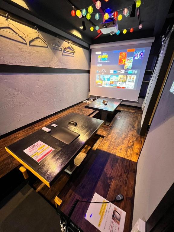 福岡市にある飲み放題カラオケお菓子食べ放題付元飲食店のエンターテイメント物件大人数可天神駅徒歩5分のテーブルとプロジェクションスクリーン付きの部屋