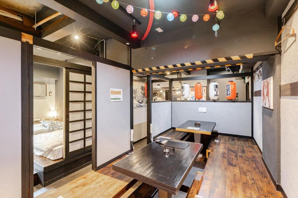 a room with a table and a bed in it at 飲み放題カラオケお菓子食べ放題付元飲食店のエンターテイメント物件大人数可天神駅徒歩5分 in Fukuoka