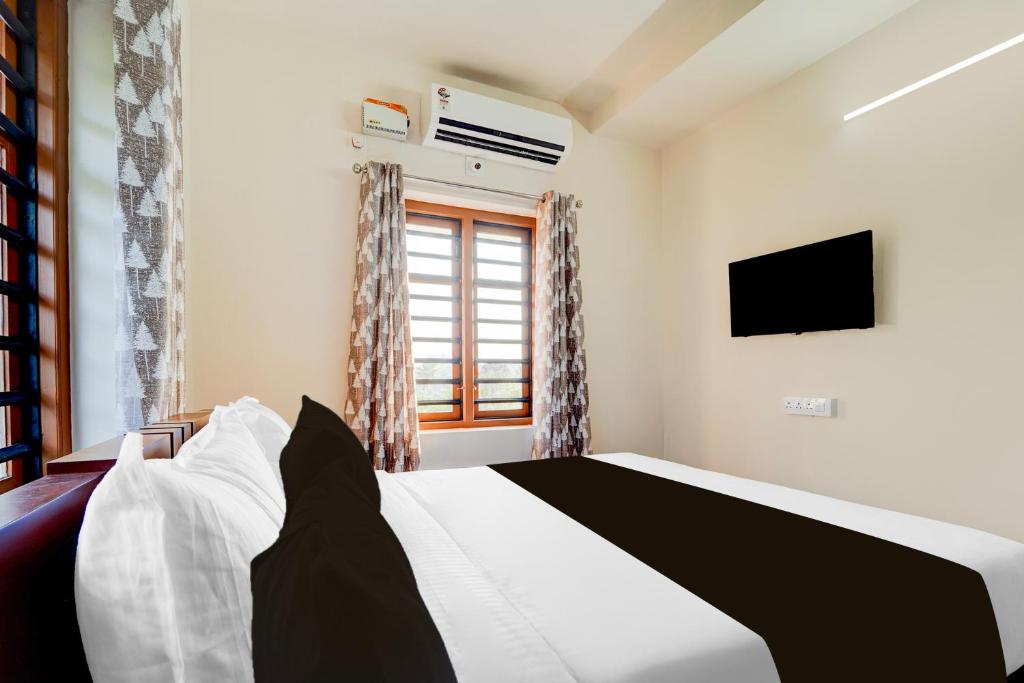 Postel nebo postele na pokoji v ubytování Super Townhouse Kalady Near Airport
