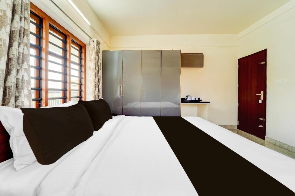 Postel nebo postele na pokoji v ubytování Super Townhouse Kalady Near Airport