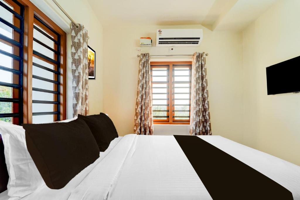 Postel nebo postele na pokoji v ubytování Super Townhouse Kalady Near Airport