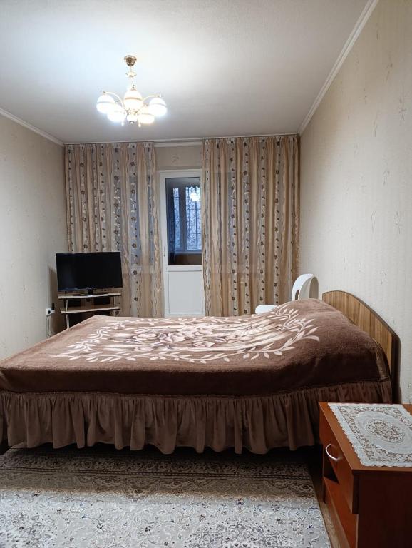 ビシュケクにあるРозаの大きなベッドと窓のある寝室