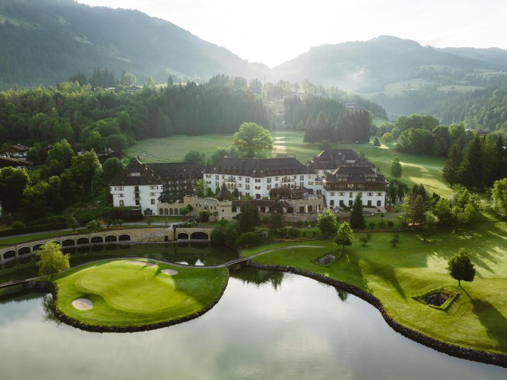 an aerial view of a golf course with a lake at Schlosshotel Kitzbühel A-ROSA Collection in Kitzbühel