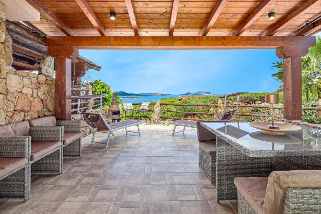an outdoor patio with wicker furniture and a view of the ocean at Villa Caterina in Punta Molara