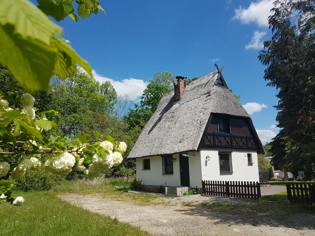 a small white house with a gray roof at Spreewaldferienhaus Kupa in Burg