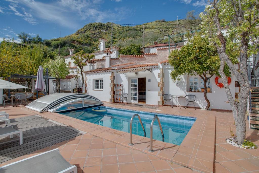a villa with a swimming pool and a house at El Estanco 14 in Vega de San Mateo