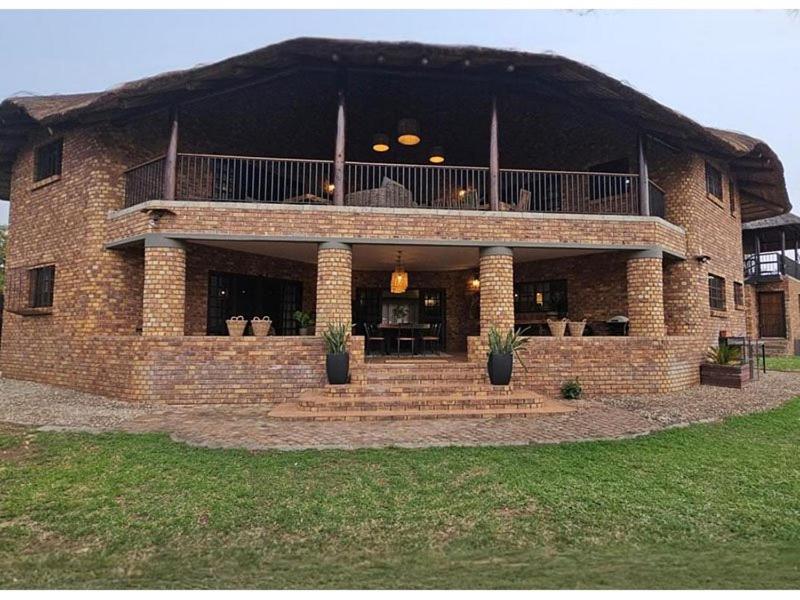 a large brick building with a balcony on it at Stay at Royal in Marloth Park