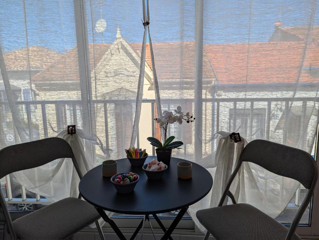 une table et des chaises devant une grande fenêtre dans l'établissement Sol-y-Days Vidourle rive droite, quartier calme 100m des plages et proche centre-ville, au Grau-du-Roi