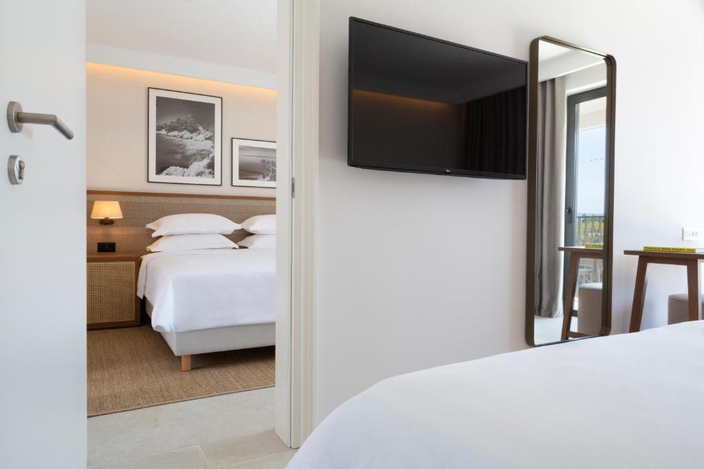 a bedroom with two beds and a large mirror at Bluesun Holiday Village Bonaca - Full Board Plus in Bol