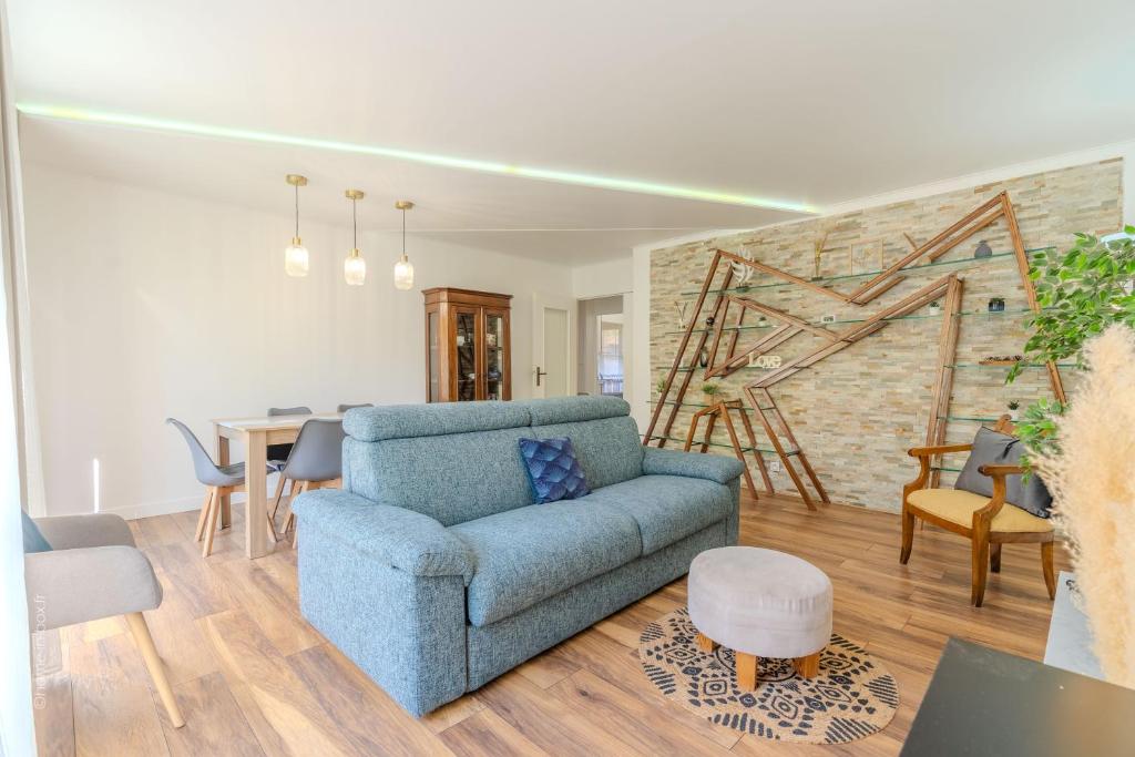 un salon avec un canapé bleu et une table dans l'établissement Nova apartment Disneyland Bmyguest, à Serris