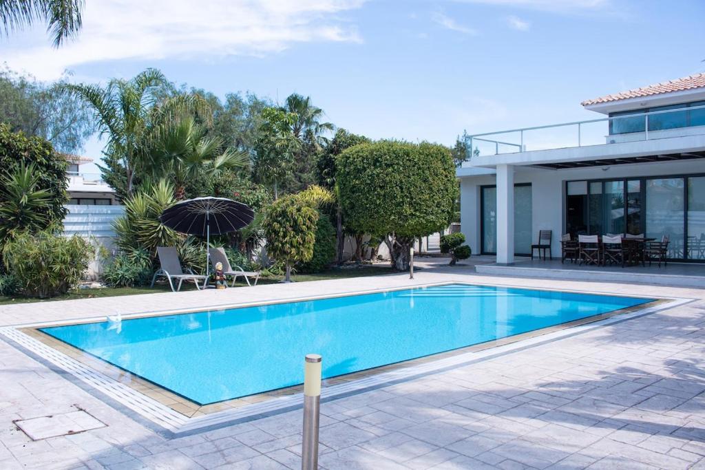 a swimming pool in front of a house at Maestro Villa in Meneou