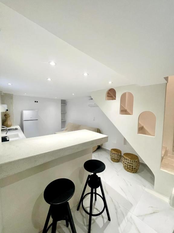 a kitchen with two stools sitting next to a counter at 2-bedroom LOFT apartment in Megali Ammos