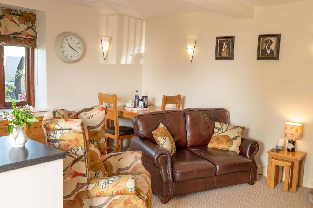 a living room with a leather couch and chairs at Ash Cottage, Castle Carrock, Nr Carlisle in Castle Carrock