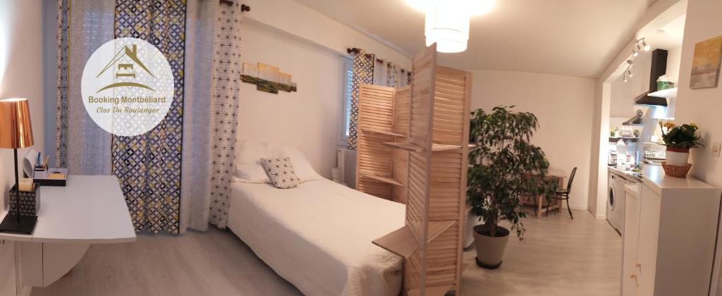a small room with a bed and a desk and a sink at Grand studio, super équipé, 2 pas du centre-ville "clos-du-boulanger" - parking privé in Montbéliard