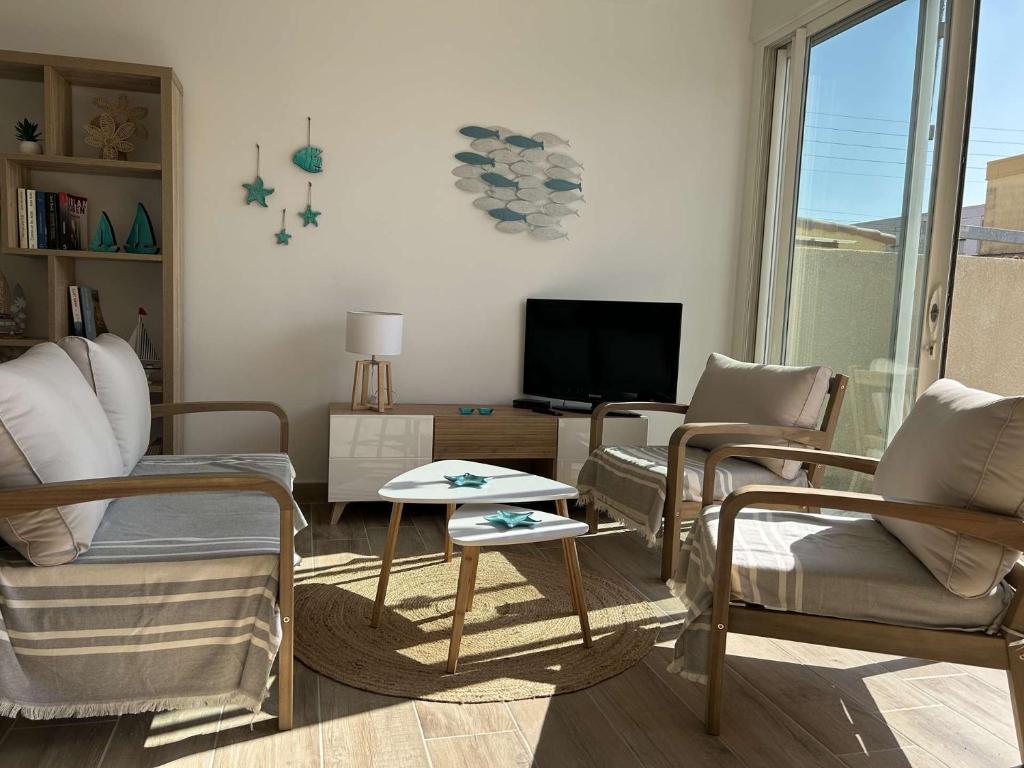 un salon avec un canapé, des chaises et une télévision dans l'établissement SP820-021 appartement T2 cabine - 4 couchages Saint Pierre la Mer, à Saint Pierre La Mer