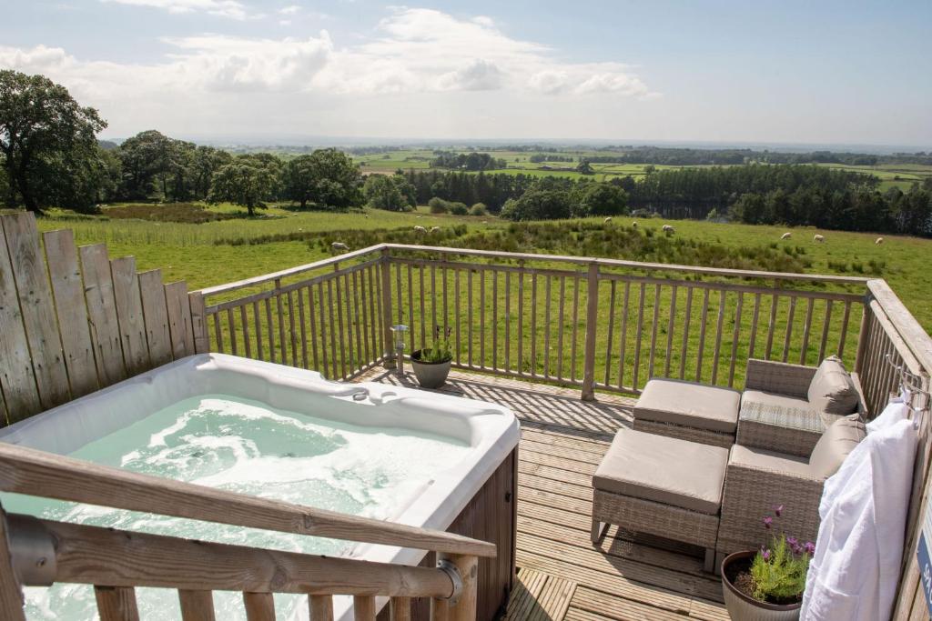 a jacuzzi tub on a deck with a view at Garth Cottage, Castle Carrock, Nr Carlisle in Castle Carrock