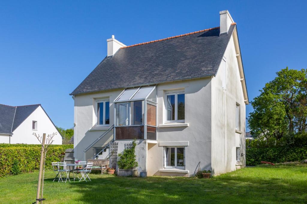 une maison blanche avec une table dans la cour dans l'établissement Kan Ar Mor, maison 300m de la plage, à Bénodet