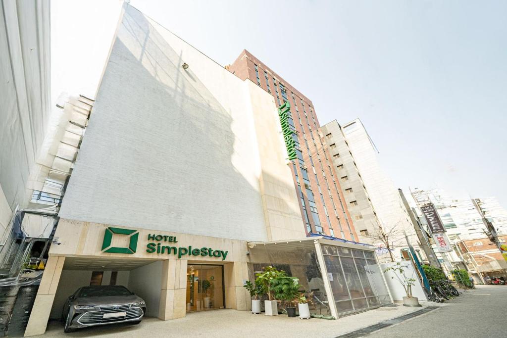 a car is parked in front of a building at SimpleStay Hotel in Jongno in Seoul