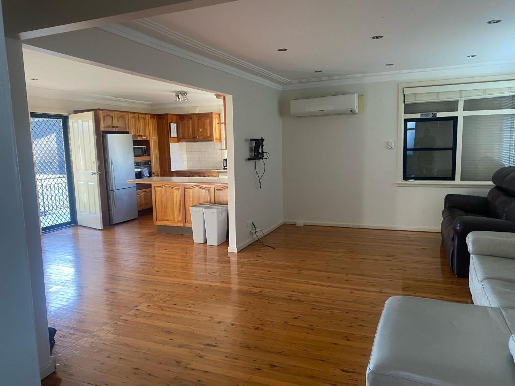 a living room with a couch and a kitchen at Spacious Queen Room with Private Balcony - GA4 in Chullora