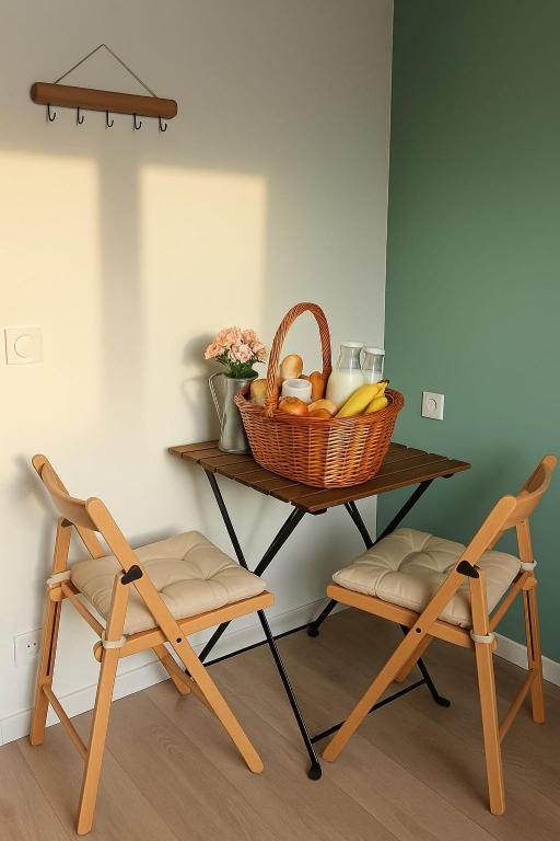 une table avec une corbeille de fruits et deux chaises dans l'établissement Chambre privée 350 m de la mer et proche et gr34 avec coin repas et micro onde, à Plouguerneau